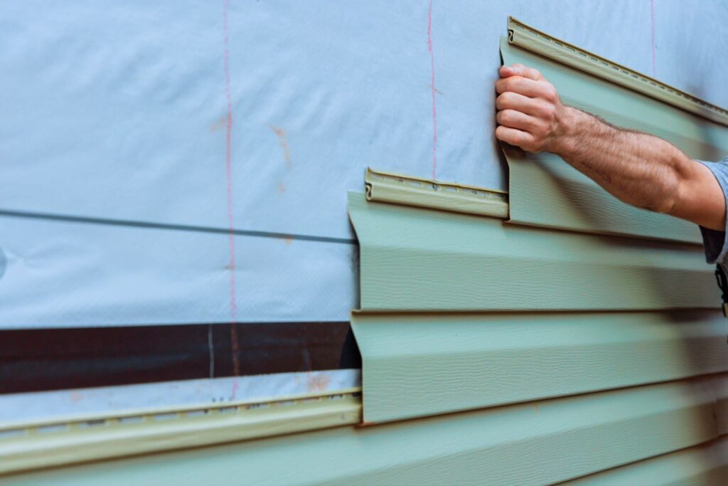 Installing siding to create an energy efficient home for better insulation and aesthetics.