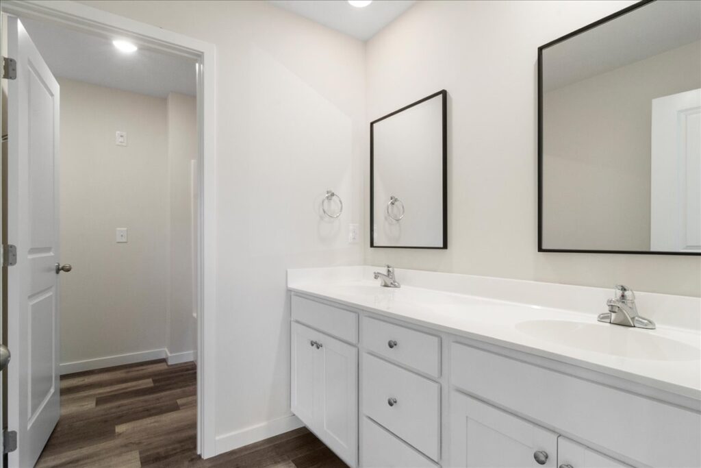 Modern bathroom interior design featuring sleek vanity, mirrors, and neutral color palette.