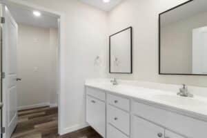 Modern bathroom interior design featuring sleek vanity, mirrors, and neutral color palette.
