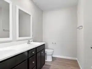 Modern bathroom interior featuring dual sinks, mirrors, and sleek design elements.