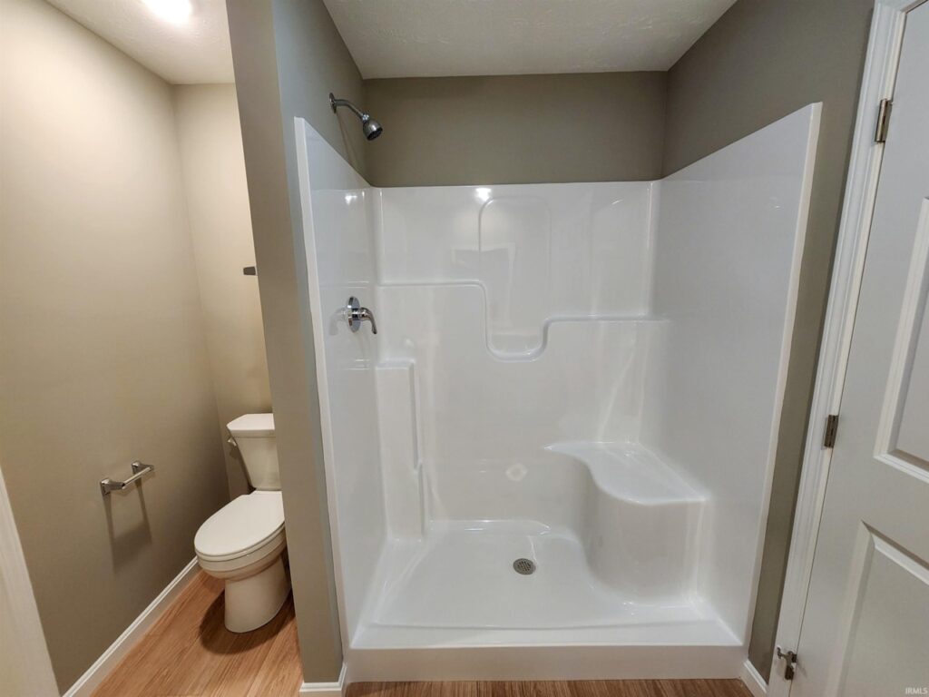 Modern bathroom featuring a spacious shower and toilet with elegant design elements.