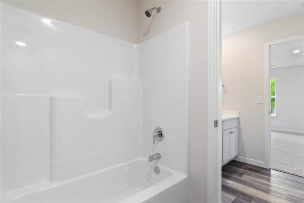 Modern clean bathroom corner featuring a sleek tub and stylish cabinetry.