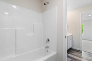 Modern clean bathroom corner featuring a sleek tub and stylish cabinetry.