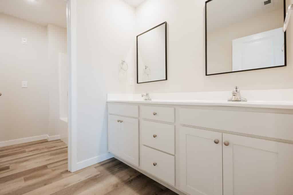 Modern clean bathroom interior with stylish mirrors and sleek cabinetry.