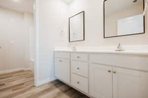 Modern clean bathroom interior with stylish mirrors and sleek cabinetry.
