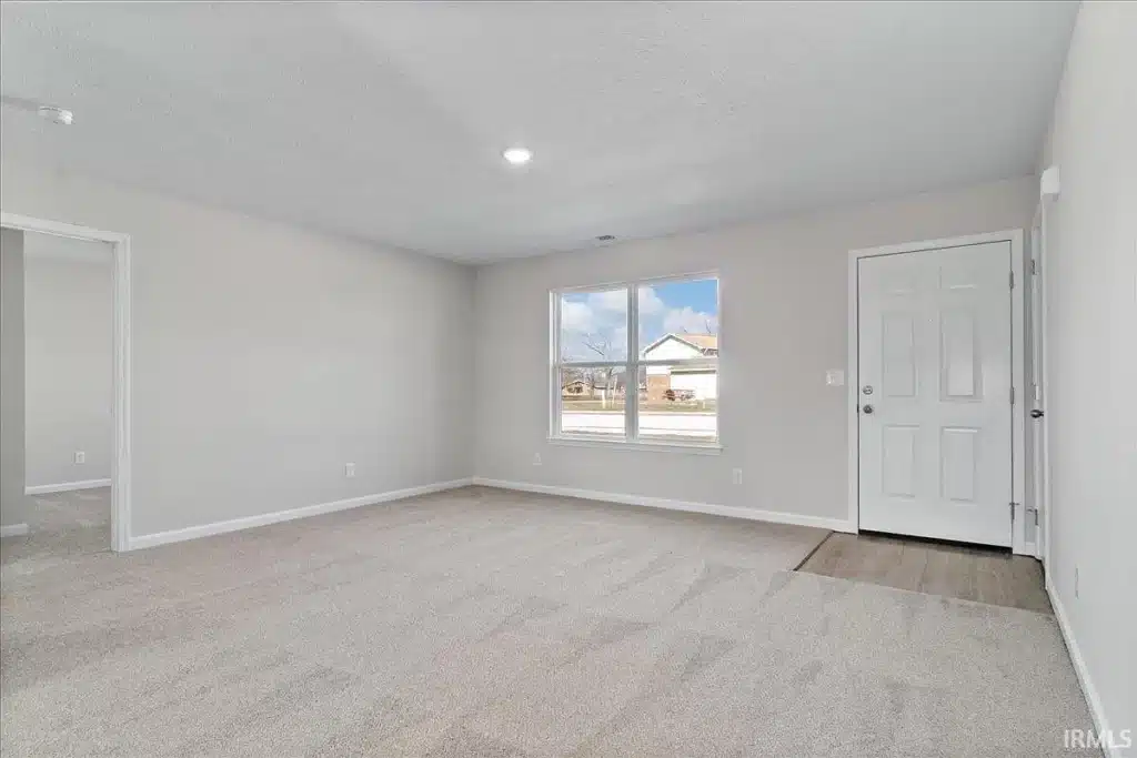 Spacious empty living room with natural light and neutral colors, ideal for customization.