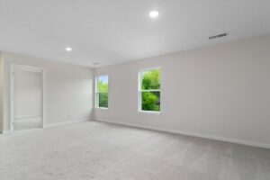 Bright, spacious empty room with natural light and fresh carpet, perfect for interior design ideas.