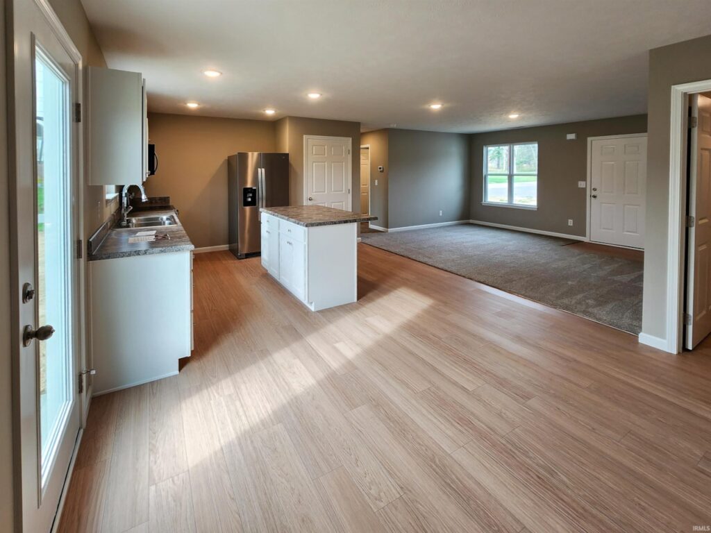 Modern kitchen-living area with stainless steel appliances and open space for entertaining.