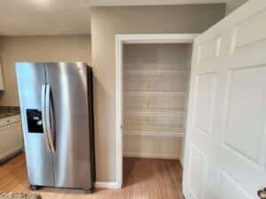 Stylish kitchen with modern refrigerator and organized corner storage area.