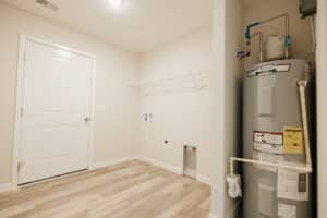 Modern laundry room with water heater and shelf for efficient organization.