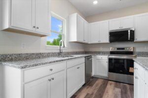 Stylish modern kitchen with white cabinets and granite countertops, perfect for cooking.