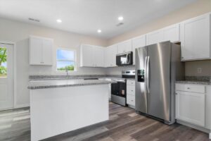 Stylish modern kitchen featuring sleek white cabinets and elegant granite countertops.