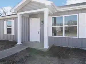 Modern home exterior featuring a welcoming porch, large windows, and stylish gray siding.