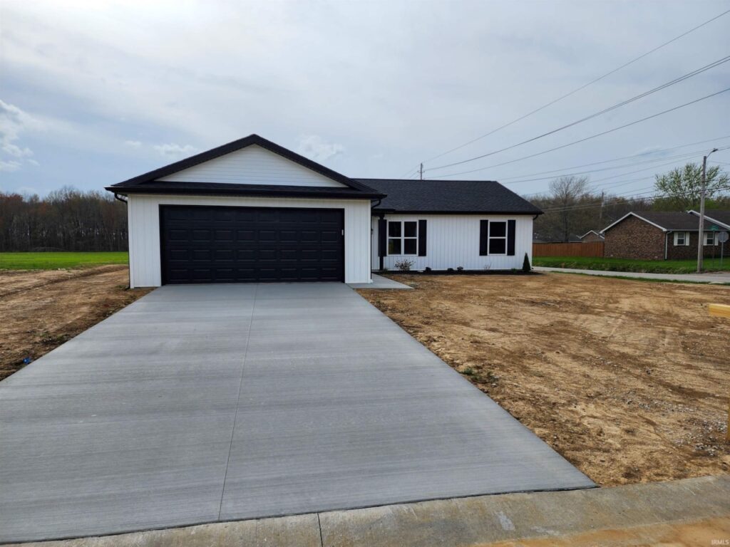 Modern home exterior with driveway and landscaping in a peaceful neighborhood setting.