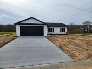 Modern home exterior with driveway and landscaping in a peaceful neighborhood setting.