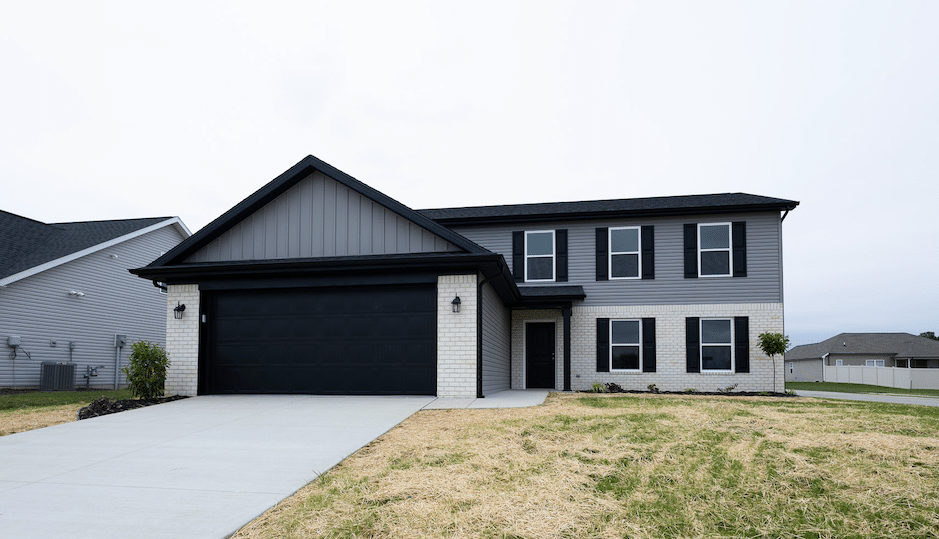 Modern two-story home with black accents and a spacious driveway.