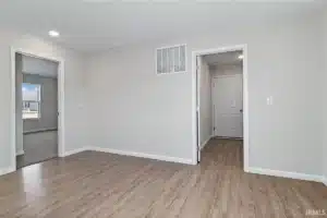 Modern room interior with light wood flooring and neutral-colored walls.