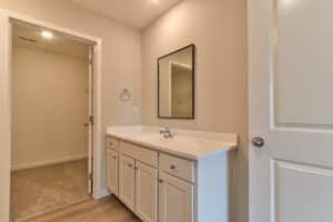 Elegant bathroom vanity with modern sink and mirror in a spacious layout.
