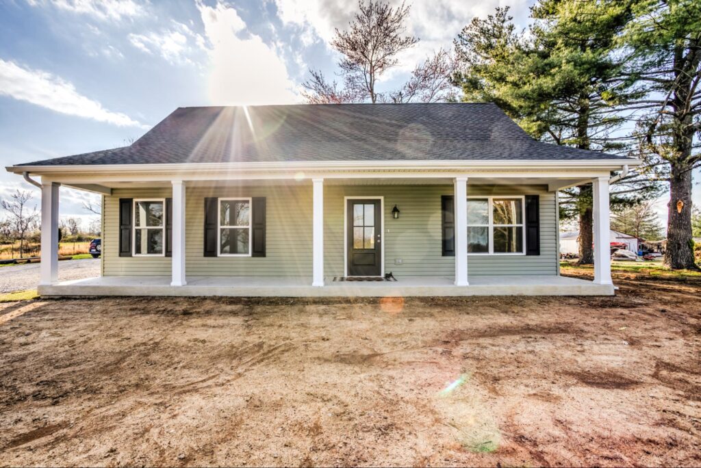 Modern house exterior with a charming front porch and beautiful landscape.