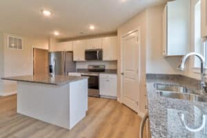 Spacious modern kitchen design featuring granite countertops and sleek appliances.