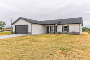 Modern single-story home exterior with garage and landscaped yard for sale.