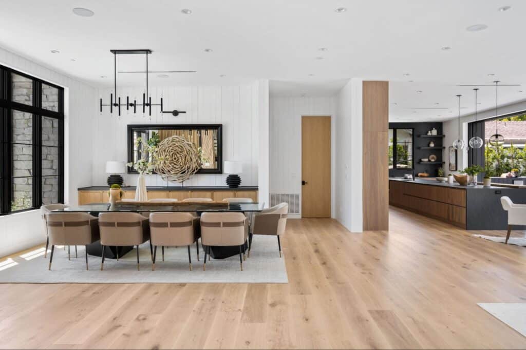 Stylish modern kitchen and dining area with wood flooring and contemporary furnishings.