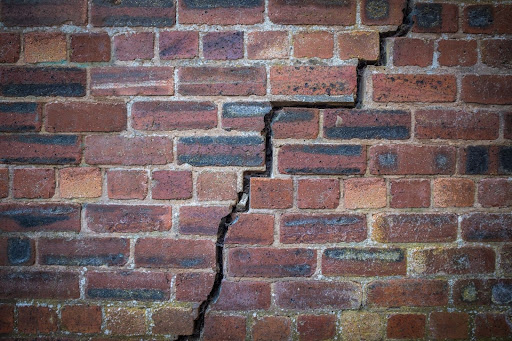 Cracked brick wall detail for home renovation and repair projects.