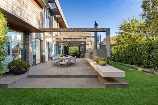 Elegant modern outdoor patio featuring contemporary architecture and lush greenery.