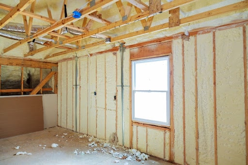 Unfinished room renovation showcasing insulation and open framing for a new design.