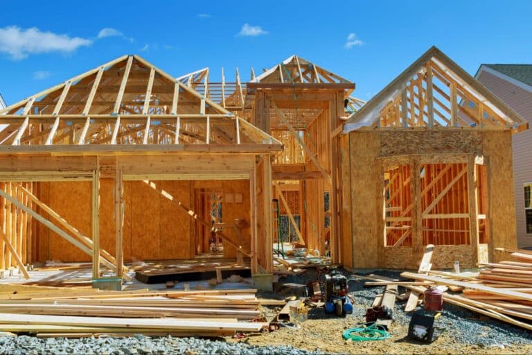 New home construction featuring wooden framing and a bright blue sky.