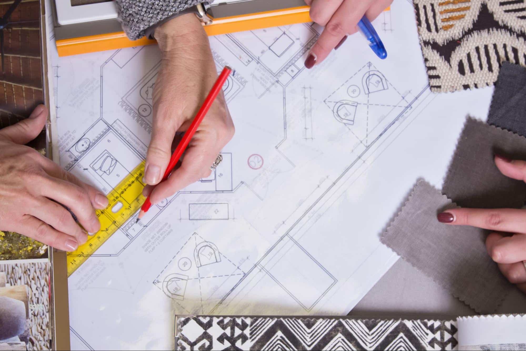 custom vs. stock plans for home building concept with blueprints on a table
