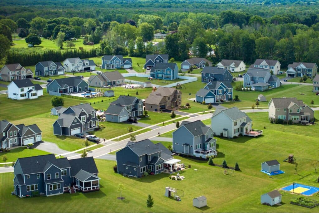 Aerial view of suburban homes and lawns in a peaceful neighborhood.
