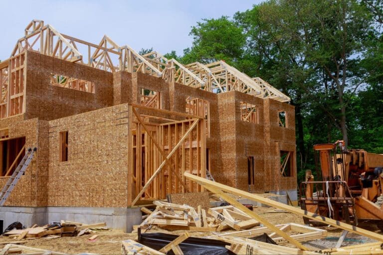 New home construction showcasing wooden framing and building materials on-site.