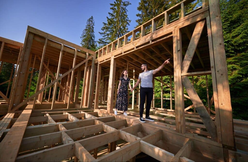 Couple planning their dream home construction in a beautiful forest setting.