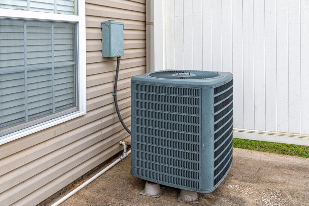 Energy-efficient outdoor AC unit installation next to a home.