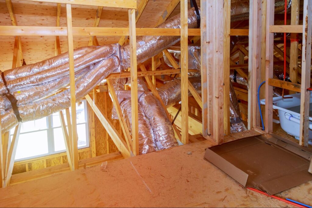 Attic ductwork and insulation installed for effective home renovation and energy efficiency.