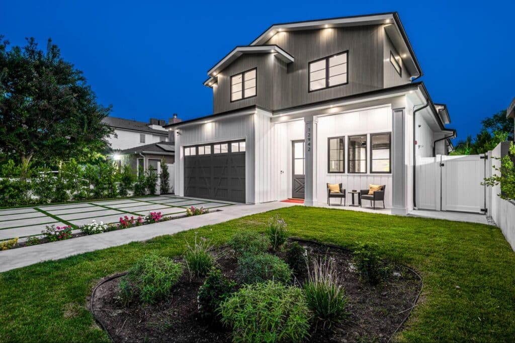 Stylish modern home with outdoor seating, landscaped yard, and inviting dusk lighting.