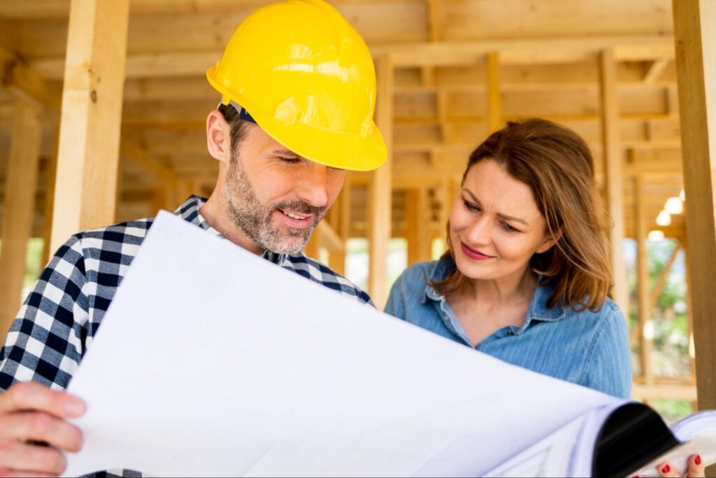 Contractor and homeowner discussing building plans during a construction project.