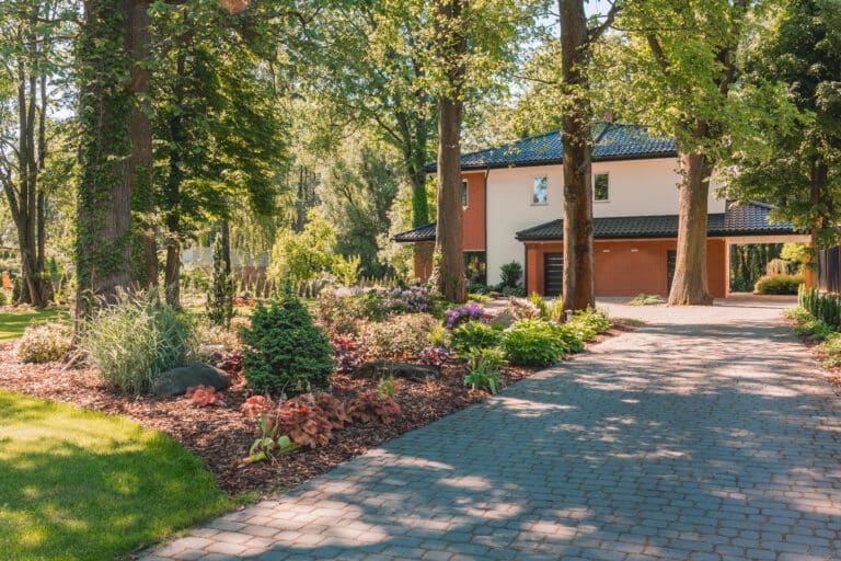 Beautiful house surrounded by a vibrant garden and lush trees.