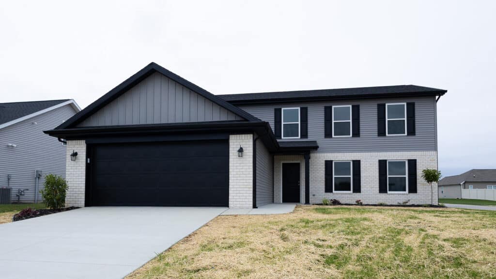 Chic two-story home featuring sleek black details and a large driveway.