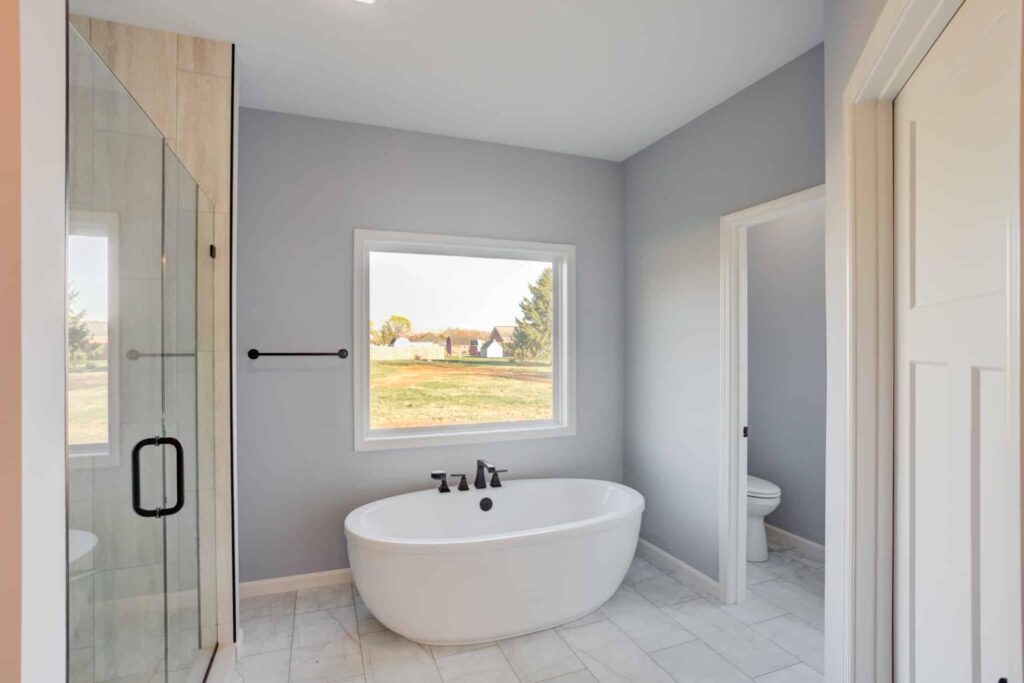 Bright modern bathroom with a freestanding tub and scenic outdoor views.