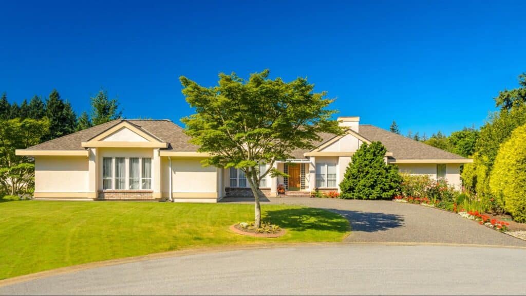 Charming suburban home nestled in lush greenery under a clear blue sky.