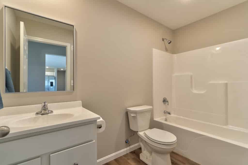 Modern bathroom featuring a bathtub, sink, and toilet in a neutral color scheme.