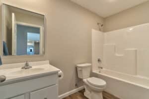 Modern bathroom featuring a bathtub, sink, and toilet in a neutral color scheme.