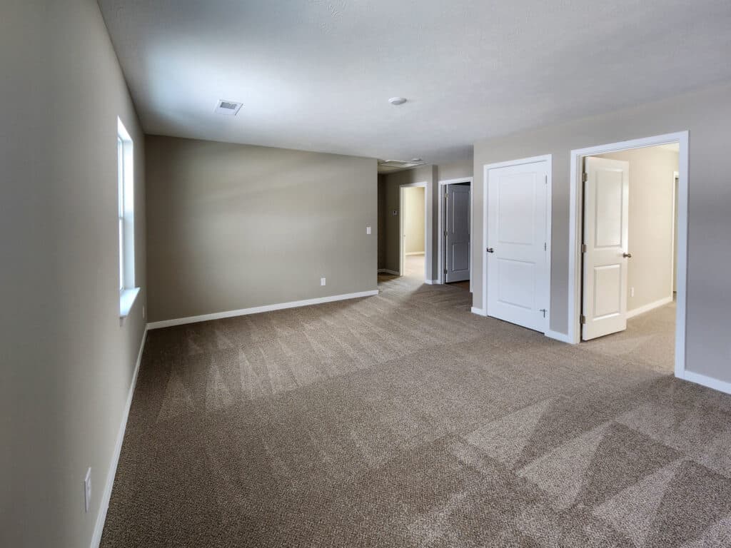 Spacious, cozy living room with light walls and soft carpet, perfect for relaxing.