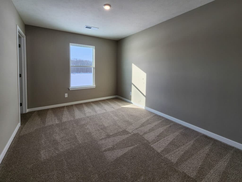 Bright, airy room with fresh carpet, sunlight streaming through a window.