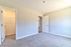 Spacious empty room with doors and light carpeting ready for personalization.