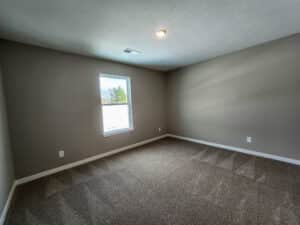 Bright, spacious room featuring natural light and soft carpet for a cozy atmosphere.