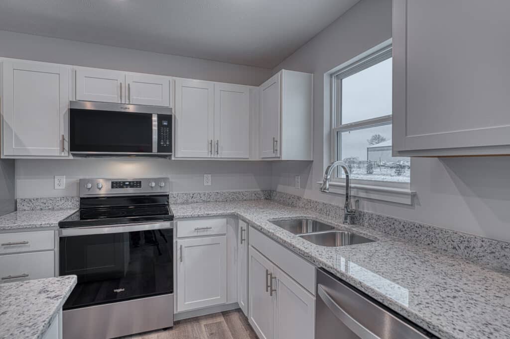 Stylish modern kitchen featuring white cabinets and elegant granite countertops.