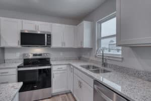 Stylish modern kitchen featuring white cabinets and elegant granite countertops.